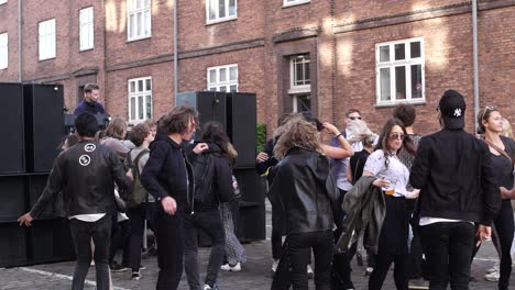 Los-Jóvenes-Asistentes-Al-Festival-Y-A-La-Fiesta-Disfrutan-De-La-Vida-En-Una-Fiesta-Callejera-Al-Aire-Libre-Bailando-Juntos,-Unidos-Como-Amigos.