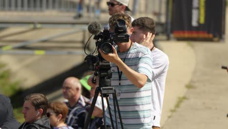 Caucasian-male-cameraman-adjusts-lens-of-camera-meticulously,slow-motion