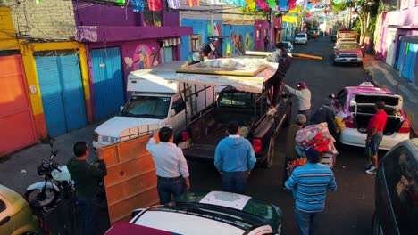 Dolly-En-Paso-Elevado-De-Un-Grupo-De-Personas-Montando-Y-Asegurando-Imágenes-Religiosas-En-Una-Camioneta-Negra-En-Los-Carnavales-De-Iztapalapa,-CDMX,-México.