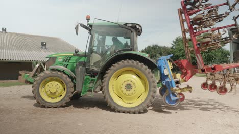 Tractor-John-Deere-Con-Arado-Girando-En-La-Granja-En-El-Suelo