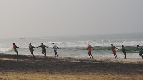 Einheimische-Eines-Traditionellen-Fischerdorfes-In-Kappil-Beach,-Varkala,-Indien,-Schleppen-Ihren-Fang-Für-Den-Tag-–-Weite-Pfanne