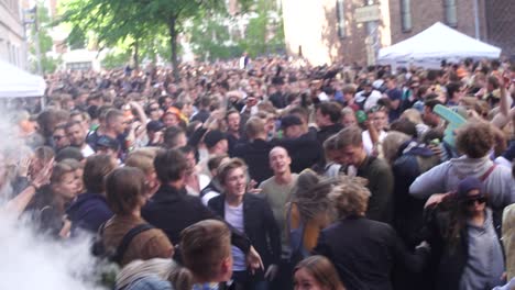 Los-Jóvenes-Asistentes-Al-Festival-Y-A-La-Fiesta-Disfrutan-De-La-Vida-En-Una-Fiesta-Callejera-Al-Aire-Libre-Bailando-Juntos,-Unidos-Como-Amigos.