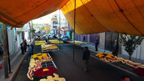 Dolly-A-Vista-De-Pájaro-En-Carpas-Protectoras-Sobre-Un-Grupo-De-Arreglos-Florales-En-El-Carnaval-De-Iztapalapa,-CDMX,-México