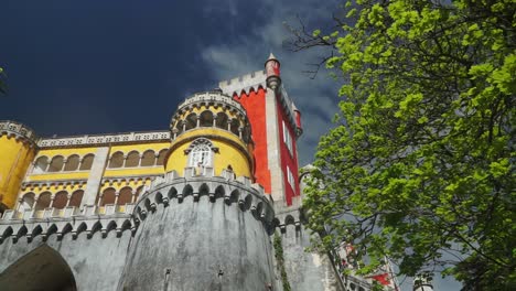 Tilting-Up-shot,-People-walking-on-the-balcony-of-The-Pena-National-Palace-in-Sintra,-Portugal