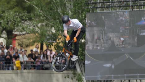 Mit-Unerschütterlichem-Selbstvertrauen-Führt-Der-Junge-Mann-Furchtlos-Beeindruckende-Stunts-Auf-Seinem-Fahrrad-In-Großer-Höhe-Im-Skatepark-Aus-Und-Meistert-Dabei-Jeden-Trick-Mit-Präzision-Und-Können