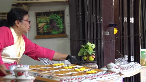 Slow-Motion-of-Thai-Woman-in-Traditional-Costume-Selling-Sweets-in-Outdoor-Shoop-in-Ancient-City-Open-Museum,-Erawan-Thailand