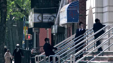 Pan-Right-From-Yeshiva-Bus-To-Young-Teenage-Males-Waiting-On-Steps-Wearing-Kippah-In-Brooklyn