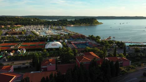 Drohnenantenne,-Langsame,-Nach-Links-Rotierende-Flugansicht-Des-Sonnenuntergangs-Von-Portoroz-Vor-Dem-Offenen-Tennisplatz-Des-ATP-Challenger-Slowenien