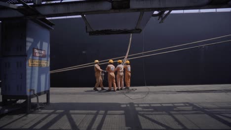 Estibadores-En-El-Trabajo-Sosteniendo-El-Amarre-De-Un-Barco-De-Fondeo-En-El-Muelle