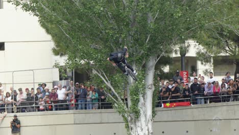 On-the-elevated-ramps-of-the-skate-park,-a-fearless-young-man-attempts-daring-tricks-on-a-bicycle,-occasionally-experiencing-exhilarating-falls-as-he-pushes-the-boundaries-of-his-skills