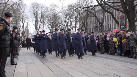 Slowmotion-track-of-a-military-band-marching-down-a-column-of-people-for-a-parade-in-the-city-of-Kaunas,-Lithuania-for-Vasario