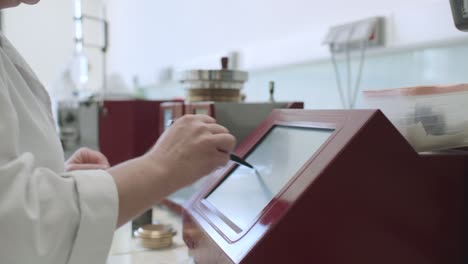 Trabajador-De-Laboratorio-Usando-Lápiz-Táctil-En-La-Pantalla-Dentro-Del-Laboratorio