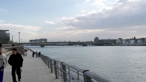 Menschen,-Die-Entlang-Der-Rheinpromenade-Am-Rheinufer-In-Köln-Spazieren