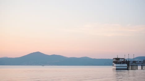 Vista-Panorámica-Del-Paisaje-De-Un-Barco-Amarrado-En-El-Lago-Bracciano,-Italia,-Al-Atardecer