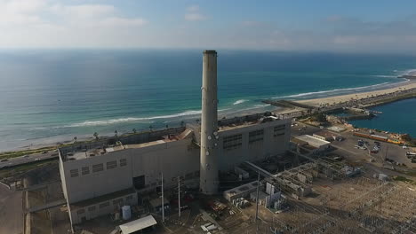 Cinematic-drone-shot-of-smokestack-at-the-NRG-Encina-Power-Plant-on-the-coast-of-Carlsbad,-CA