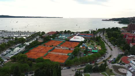 Avión-Teledirigido-Delantero-Volando-Sobre-La-Ciudad-Costera-De-Portoroz---Atp-Challenger-Slovenia-Open-Tennis-Grounds