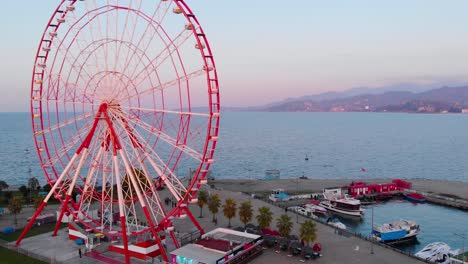 Aéreo,-órbita,-Disparo-De-Drone,-Alrededor-De-La-Noria,-En-La-Costa-Del-Mar-Negro,-Durante-La-Puesta-De-Sol,-En-La-Ciudad-De-Batumi,-Adjara,-Georgia