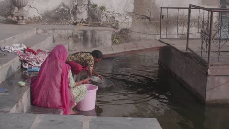 Mujeres-Indias-En-El-Estanque-Inmersas-En-La-Eterna-Tradición-De-Lavar-La-Ropa.