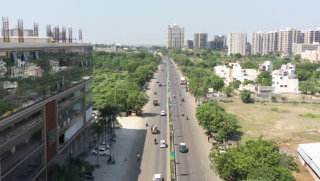 aerial-drone-shot-drone-CAMERA-is-moving-forward-where-there-is-a-road-in-the-middle-of-a-lot-of-surrounding-bushes-where-a-lot-of-old-truck-rickshaws-are-seen-going-down-the-road