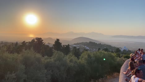 Tourists-overlooking-beautiful-sunset-from-the-highest-mountain-village-of-Zia,-Sunset-balcony-Taverna-in-Zia-Kos-island