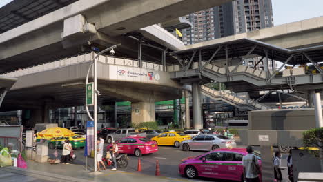 Peatones-Y-Viajeros-Esperando-Sus-Viajes-En-Una-Parada-De-Autobús-Y-En-La-Estación-De-Tren-En-Bangkok,-Tailandia