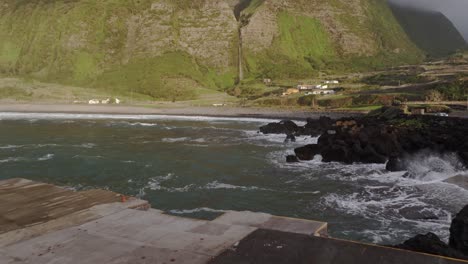 Fotógrafo-Con-Chaqueta-Amarilla-Cerca-Del-Mar-Agitado-En-La-Isla-De-Azores,-Aéreo