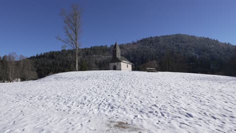 Plano-Amplio-De-La-Chapelle-St-Florent-En-La-Cima-De-Una-Colina-Cubierta-De-Nieve-Cerca-Del-Lago-Longemer.