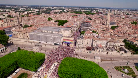 Teilnehmer-Der-Gay-Pride-Parade-überschwemmen-Straßen,-Während-Eine-Riesige-Regenbogenfahne-Historische-Architektur-Schmückt