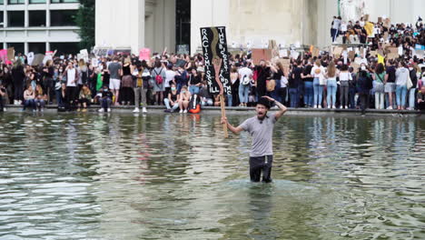 Ein-Junger-Mann-Demonstriert-Emotional-Gegen-Gewalt-Und-Rassismus,-Während-Er-Im-Knietiefen-Wasser-Steht