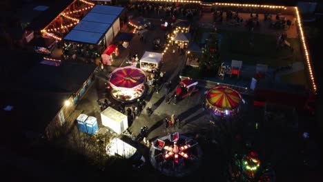 Festival-De-Feria-De-Navidad-Iluminado-En-El-Aparcamiento-Del-Pub-Del-Barrio-Por-La-Noche-Vista-Aérea