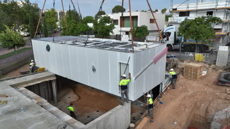 Trabajadores-Colocando-Casa-Modular-Prefabricada-En-El-Sitio-De-Construcción