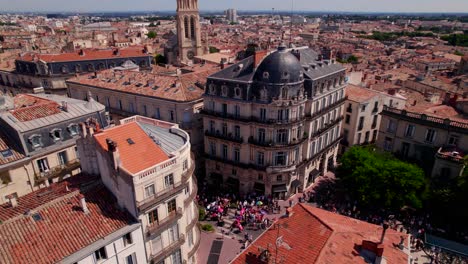 Aerial-reveal-of-gay-pride-parade-participants-carrying-rainbow-flag-on-street