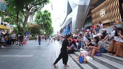 Una-Mezcla-De-Mujeres-Locales,-Filipinas-E-Indonesias-Están-Sentadas-En-Las-Escaleras-Frente-A-Los-Centros-Comerciales.