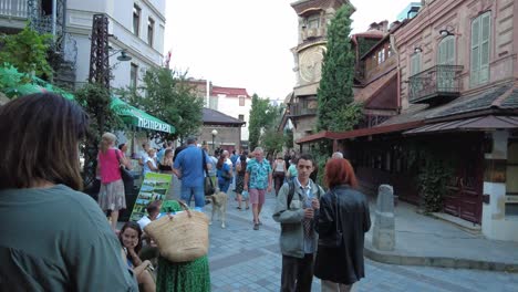 Torre-Del-Reloj-De-Tbilisi-En-Georgia,-País,-La-Arquitectura-Del-Cáucaso,-Atracción-Turística,-Punto-De-Referencia,-Musical,-Reloj-Torcido,-Visitante-Esperando-En-El-Centro-Para-Mostrar-Una-Actuación-En-La-Ciudad-Vieja,-Recorrido-A-Pie-En-Verano.