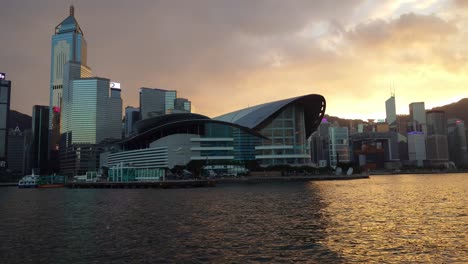 Centro-De-Convenciones-Y-Exposiciones-De-Hong-Kong-Con-Nubes-Doradas-Al-Atardecer-De-Color-Naranja-En-El-Fondo