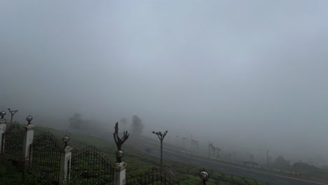 Toma-Cinematográfica-De-Timelapse,-Hay-Muchos-árboles-En-Las-Colinas-Y-Se-Ve-Niebla-En-La-Carretera.