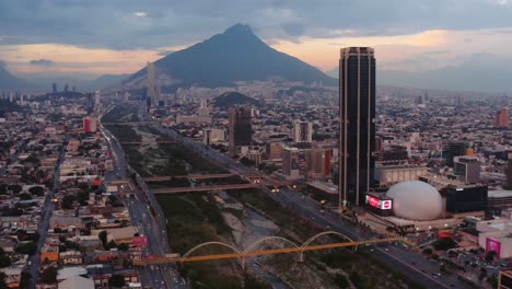 Increíble-Vista-Del-Atardecer-De-Monterrey,-México-Con-Puentes-Sobre-El-Río-Santa-Catarina-Y-Edificios-Que-Llenan-La-Extensa-Ciudad-En-Un-Valle-Rodeado-De-Altos-Picos-Montañosos