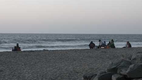 Gente-En-Una-Playa-En-Carlsbad-California-Durante-La-Puesta-De-Sol