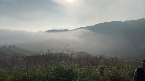 Filmische-Zeitrafferaufnahme,-Viele-Menschen-Blicken-Auf-Die-Berge-Und-Rund-Um-Die-Berge-Ist-Viel-Nebel-Zu-Sehen