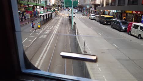 Vista-De-La-Ventana-POV-Desde-La-Parte-Trasera-Del-Segundo-Piso-De-La-Parada-De-Salida-Del-Tranvía-En-El-Centro-De-Hong-Kong