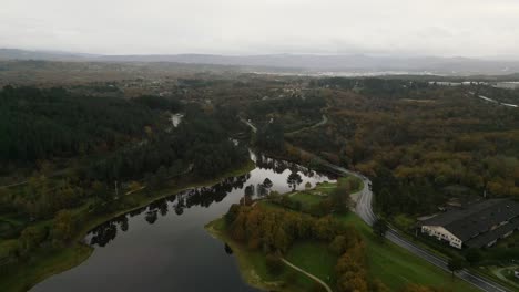 Beautiful-aerial-drone-shot-of-the-landscape-of-the-Cachamuiña-reservoir-on-a-cloudy-day-surrounded-by-trees