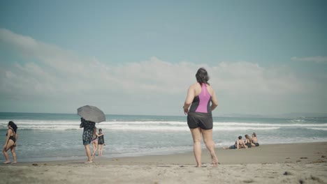 Clean-Beach-Tourists-Walk-to-the-Ocean-Waves-with-Other-People-Sunbathing,-Philippines