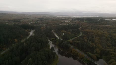 Wunderschöne-Luftdrohnenaufnahme-Der-Landschaft-Des-Cachamuiña-Stausees-An-Einem-Bewölkten-Tag,-Umgeben-Von-Seinen-Straßen,-Alleen-Und-Bäumen