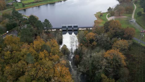 Hydraulische-Tore-Des-Cachamuiña-Stausees,-Die-An-Einem-Bewölkten-Tag,-Umgeben-Von-Bäumen-Im-Winter,-Das-Wasser-Durchlassen