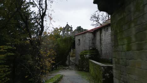 Corredor-Que-Conduce-A-Una-Entrada-Estrecha-Entre-Rocas-Y-Paredes-Grises-Con-Lamas-De-Una-Construcción-Majestuosa-Y-Antigua-Rodeada-De-árboles-Y-Naturaleza