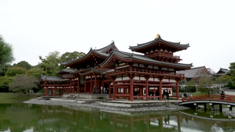 People-stroll-through-Byōdō-in,-a-Buddhist-temple-located-in-the-city-of-Uji-in-Kyoto-Prefecture,-Japan