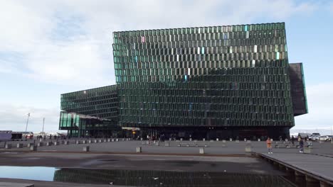 Multitud-De-Personas-Frente-A-La-Sala-De-Conciertos-Y-Al-Centro-De-Conferencias-Harpa-En-Reikiavik,-Islandia