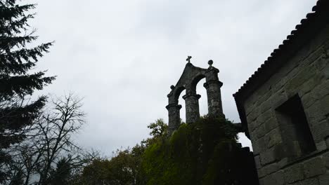 Alte-Katholische-Architekturstruktur,-Umgeben-Von-Bäumen-Und-Natur,-Mit-Einem-Christlichen-Kreuz-An-Der-Spitze