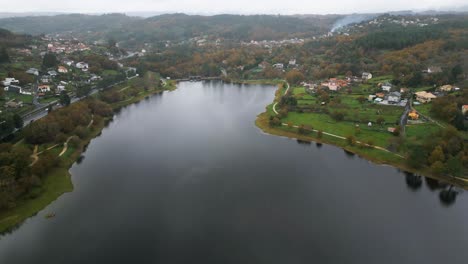 Hermosa-Toma-Aérea-Con-Drones-Del-Paisaje-Del-Embalse-De-Cachamuiña-En-Un-Día-Nublado-Rodeado-De-árboles