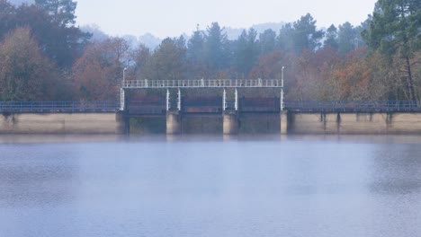 Hydraulische-Tore-Des-Cachamuiña-Stausees-An-Einem-Bewölkten-Tag,-Umgeben-Von-Bäumen-Im-Winter